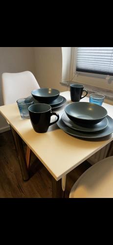 une table avec quatre bols noirs et des assiettes dessus dans l'établissement Casa qui Piccola Eifel, à Hellenthal