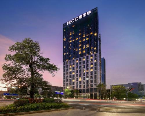 a tall building with a sign on the side of it at Xinghe Times Apartment - Shenzhen North Railway Station in Shenzhen
