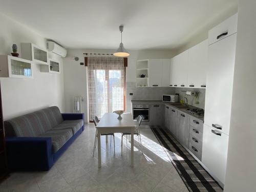Casa Lia في فيشانو: مطبخ وغرفة معيشة مع أريكة وطاولة