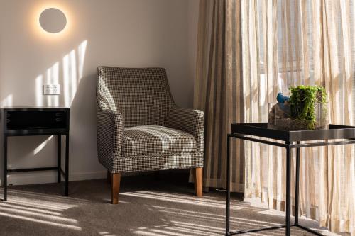 a living room with a chair and a side table at Best Western Newmarket Inn & Suites in Auckland