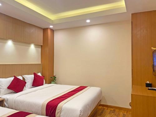 a bedroom with two beds with red pillows at Hotel Nilakantha Pvt. Ltd in Kathmandu