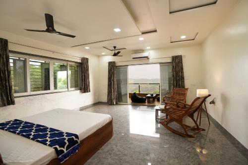 a bedroom with a bed and a chair and a couch at Aksha Villa in Panchgani