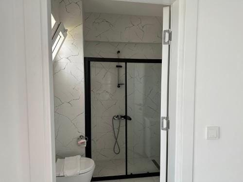 een badkamer met een toilet en een glazen douche bij Villa Selin in Ovacik