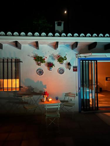 een muur met een tafel en stoelen voor een gebouw bij Casa Pipa Alhaurín el Grande - vrijstaande casita met privé zwembad en grote tuin in Málaga