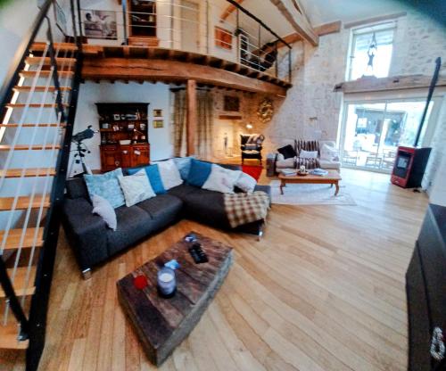 a living room with a couch and a staircase at Gite La Pipistrelle in Rudeau-Ladosse