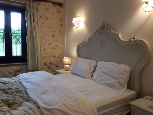 a bed with white sheets and pillows in a bedroom at Gite La Pipistrelle 