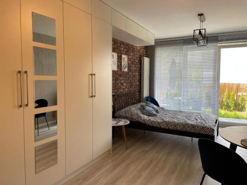 a bedroom with a bed and a large window at Apartamet Poezji A04 Blue in Gliwice