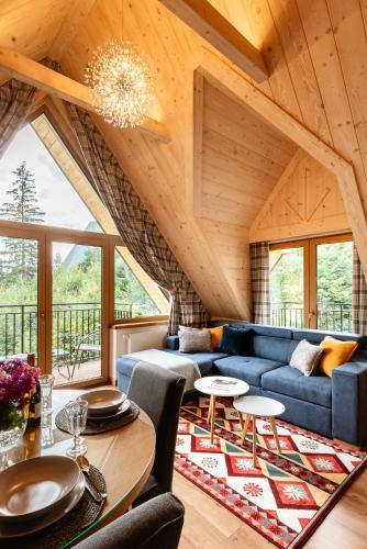 a living room with a blue couch and a table at Apartamenty Blisko TATR Zakopane in Zakopane