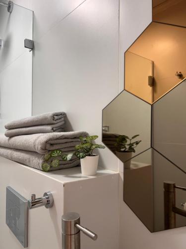 baño con espejo y toallas en la encimera en White Door Apartments en Haifa