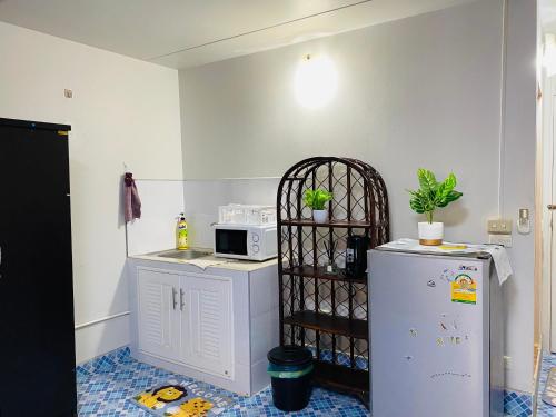 a kitchen with a white refrigerator and a microwave at Condo popular T8 Fl.5 in Thung Si Kan