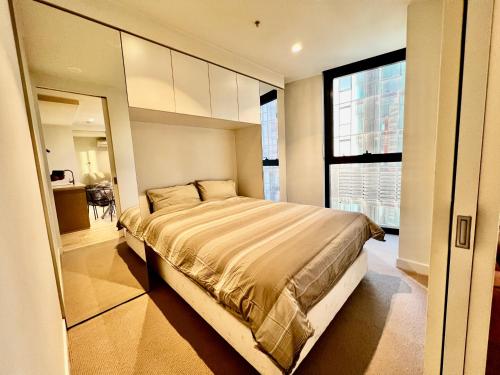 ein Schlafzimmer mit großem Bett und Fenster in der Unterkunft City Central Location, Parking and 2 Bed Apartment in Melbourne