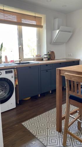 cocina con armarios azules, fregadero y lavavajillas en Sepa Apartement en Kuressaare