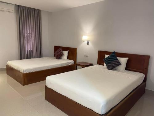 um quarto de hotel com duas camas e uma janela em Chhay Ing Guesthouse 