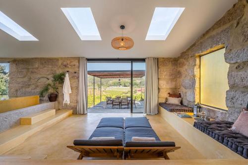 una sala de estar con sofás azules y una pared de piedra. en Lemon Villa-indoor pool, en Valpedre