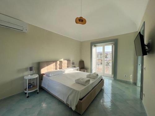 a bedroom with a bed and a flat screen tv at Palazzo Palumbo in Procida