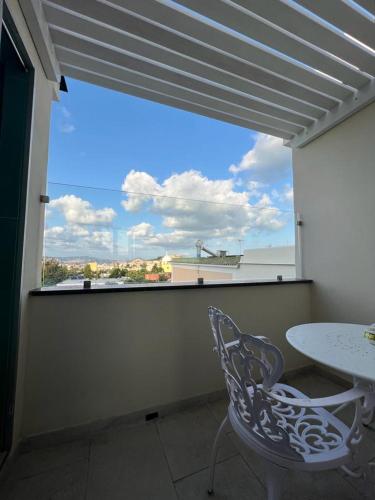 a patio with a table and a chair and a window at Palazzo Palumbo in Procida
