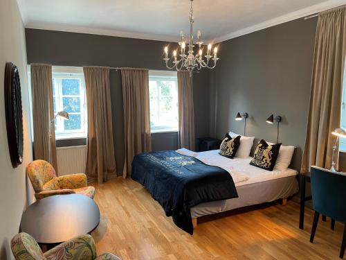 a bedroom with a bed and a chandelier at Brattrein Hotell - Unike Hoteller in Notodden