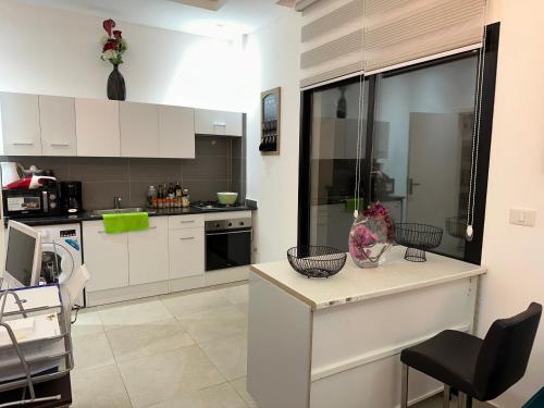 a kitchen with white cabinets and a counter top at SYN - Corniche in Brazzaville