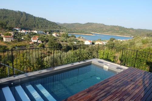 a swimming pool on a balcony with a view of a lake at Casa Rio, Amalia in Ferreira do Zêzere