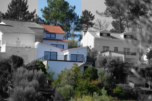 a row of white houses on a hill with trees at Casa Rio, Amalia in Ferreira do Zêzere