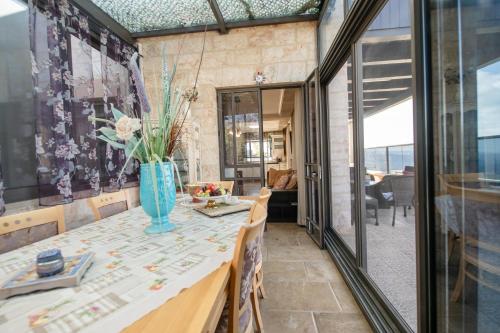 a dining room with a table with a vase on it at הים פוגש את ההר- בית בלב הגליל Sea & Mount in Adamit