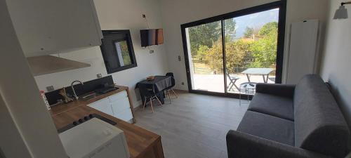 a living room with a couch and a kitchen at LE REFUGE DES CASCADES in Vernet-les-Bains