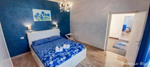 a blue bedroom with a bed with white shoes on it at Ortensia blu in Lenola