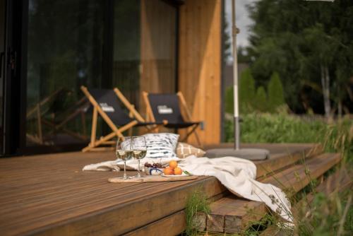 einen Tisch mit Weingläsern und Obst auf dem Deck in der Unterkunft hejHUS w Strzyżach 