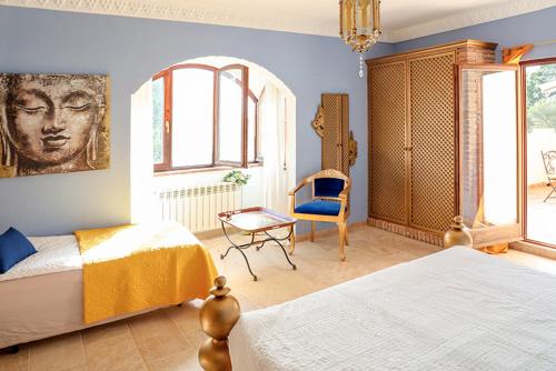 a bedroom with two beds and a chair at Finca verde de la luz in Barbate