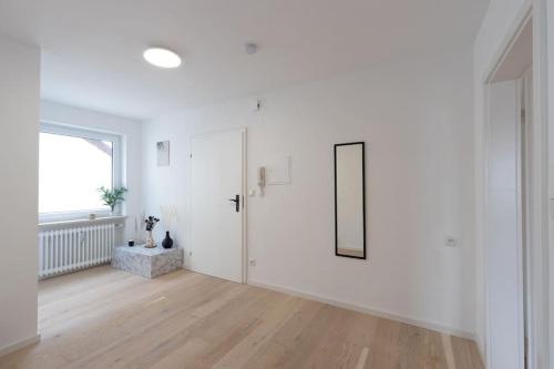 um quarto branco com uma porta e uma janela em Stylish Apartment near Munich em Moorenweis