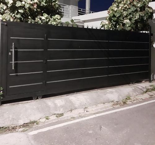 un portail noir sur le côté d'une rue dans l'établissement Apartamentos felix Las terrenas, à Las Terrenas