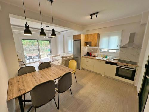 een keuken en eetkamer met een tafel en stoelen bij Maison Rivière in Lefkada