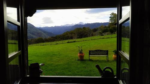 a window with a view of a bench in a field at La Casona de Torió in Torío