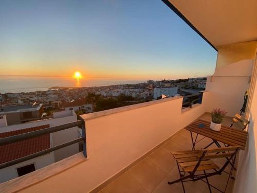 a balcony with a table and a bench on a building at Ericeira Mar à vista - Seaview apartment in Ericeira
