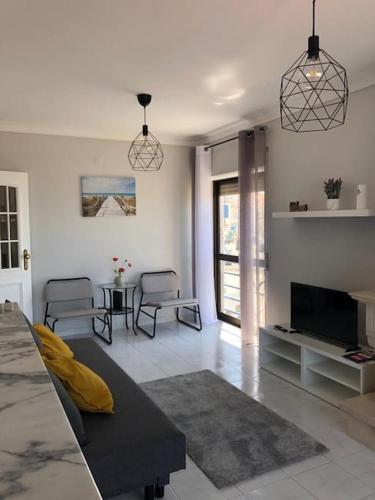 a living room with a couch and a television at Ericeira Mar à vista - Seaview apartment in Ericeira