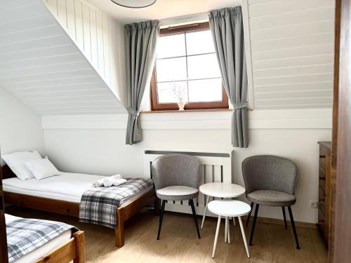 a room with a bed and two chairs and a window at Harmony Park in Kondrajec