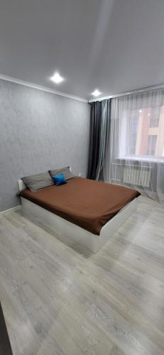 ein Schlafzimmer mit einem großen Bett in einem Zimmer in der Unterkunft Апартаменты на Кенесары 83 in Kökschetau