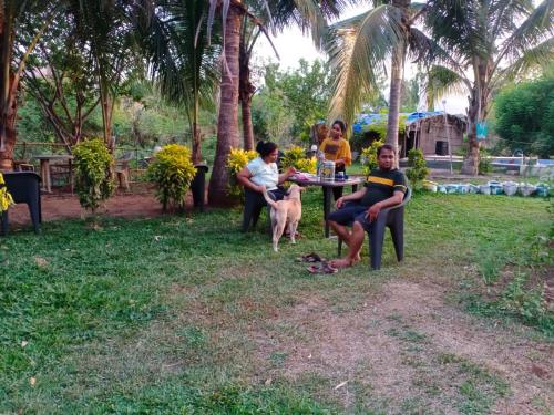 a group of people sitting at a table in the grass at Shrushtiban farms in Dhamni