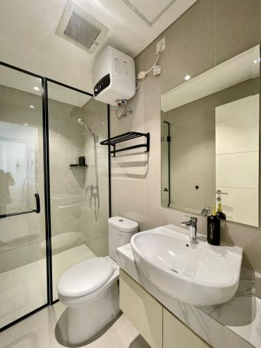 a white bathroom with a toilet and a sink at Insta-worthy staycation at 2BR luxury Apt - Podomoro Empire Tower in Medan