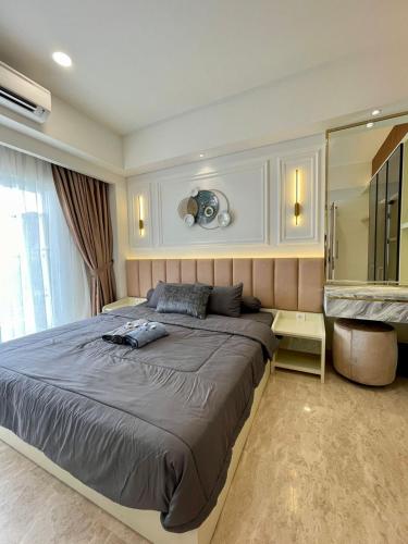 1 dormitorio con 1 cama grande y espejo grande en Insta-worthy staycation at 2BR luxury Apt - Podomoro Empire Tower, en Medan