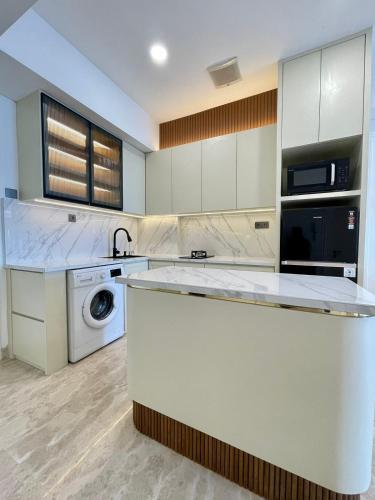 a kitchen with a sink and a washing machine at Insta-worthy staycation at 2BR luxury Apt - Podomoro Empire Tower in Medan