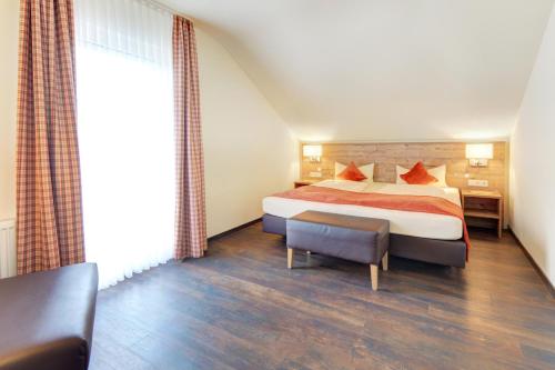 una camera d'albergo con un letto e una grande finestra di Ferienwohnungen Gästehaus Gaiser a Baiersbronn