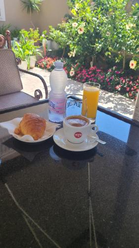 a table with a cup of coffee and a plate of food at Hotel Blue Eyes in Vlorë