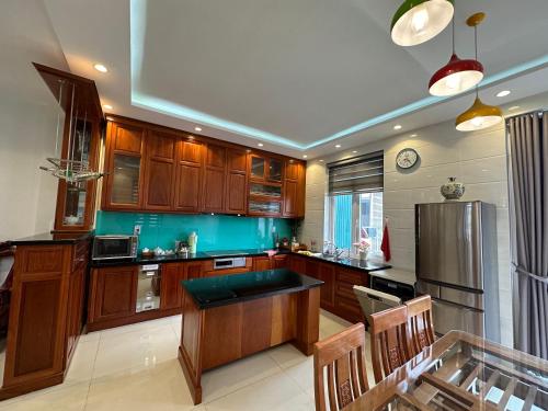 a kitchen with wooden cabinets and a stainless steel refrigerator at Đà Lạt Villa 84 Hồ Xuân Hương in Da Lat