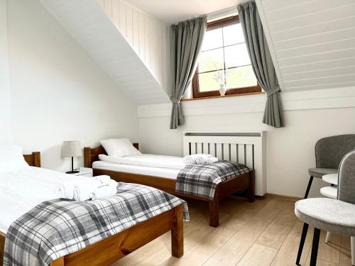 a bedroom with two beds and a window and a chair at Harmony Park 