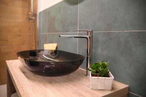 a black sink on a wooden counter in a bathroom at Maison De Ruelle in Barletta