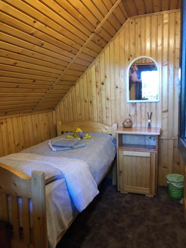 a bedroom with a bed in a wooden cabin at Inchirieri cabana- “Chalet Rustique” in Covasna