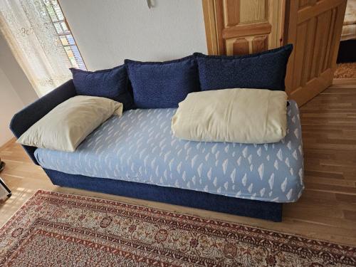 Un sofá azul con dos almohadas. en SARAJEVO APARTMENT, en Sarajevo