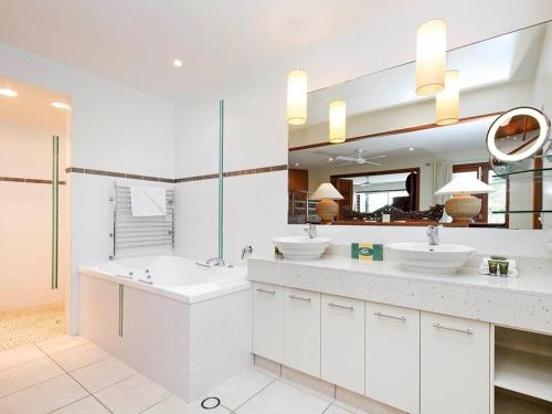 a white bathroom with two sinks and a mirror at Noosa Dua Apartment 2, Noosaville in Noosa Heads