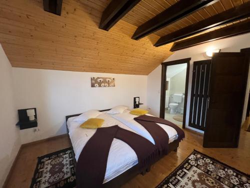 ein Schlafzimmer mit großem Bett und Holzdecke in der Unterkunft Trout Cottage in Bran